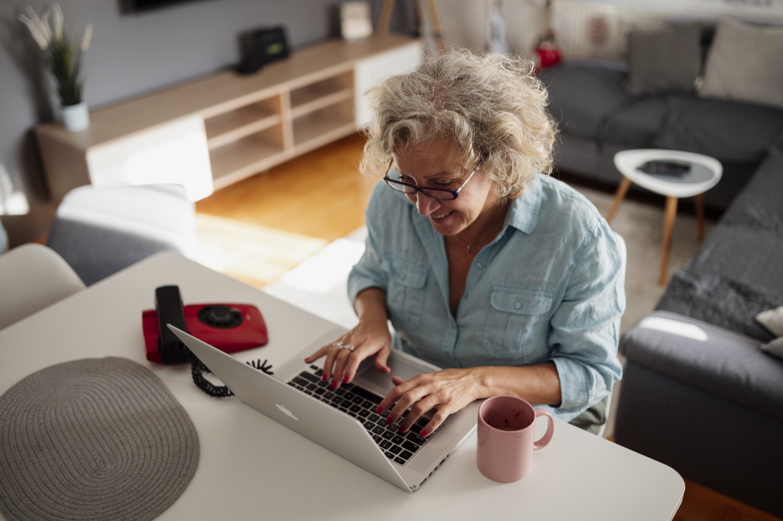 Older adult using a laptop at home, representing work and Social Security planning
