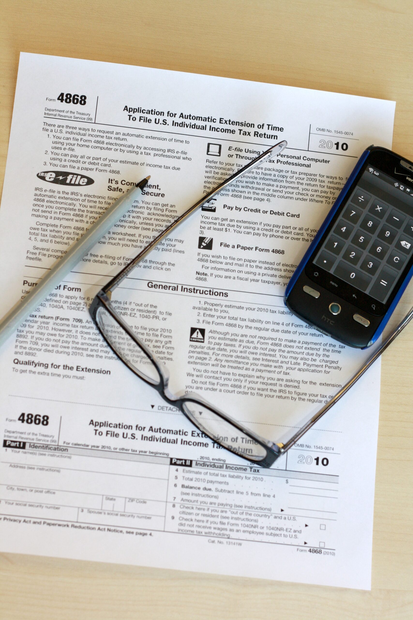 roth-conversion-tax-paperwork Tax paperwork with pen and glasses representing Roth conversion planning before required minimum distributions