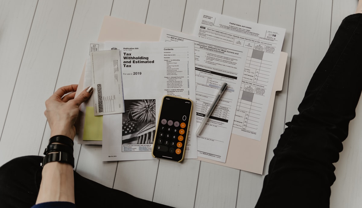 Calculator and paperwork representing used-car insurance transfer and purchase planning